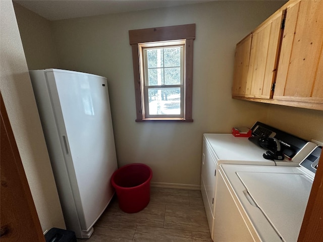 laundry area with cabinet space, baseboards, and washer and dryer