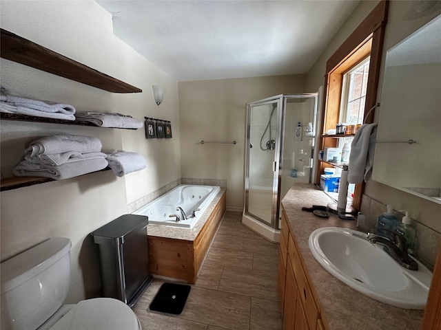 full bath with vanity, a tub with jets, a shower stall, and toilet