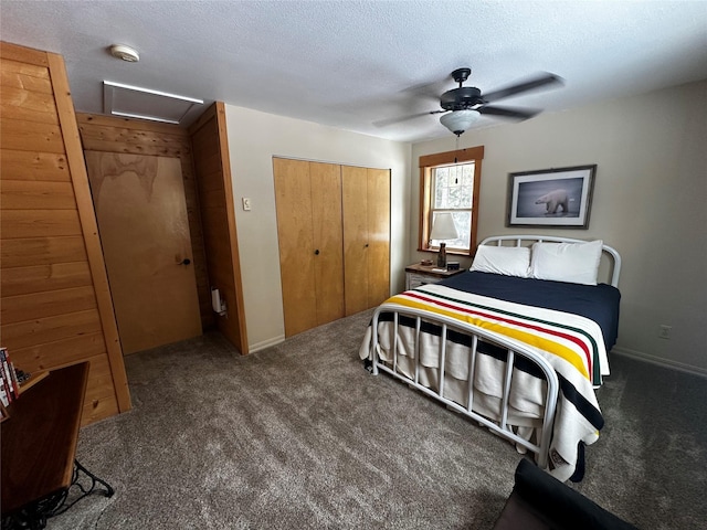 carpeted bedroom featuring a textured ceiling, a ceiling fan, baseboards, a closet, and attic access