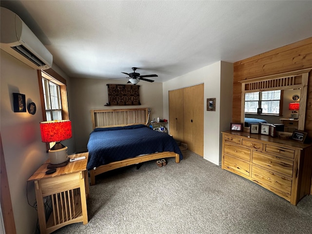 22 Pinewoods Dr, Trout Creek, MT 59874 - bedroom featuring an AC wall unit, carpet flooring, a ceiling fan, a closet, and wooden walls