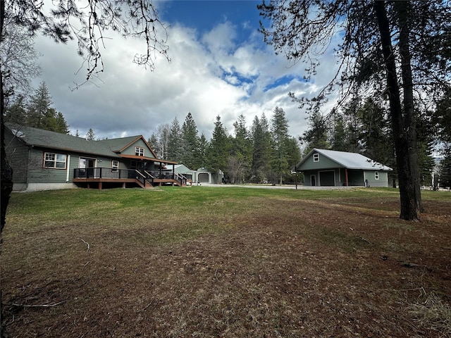 22 Pinewoods Dr, Trout Creek, MT 59874 - view of grassy yard featuring a deck, an outbuilding, and a detached garage