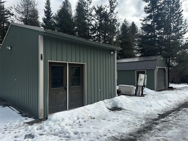 snow covered garage featuring a detached garage