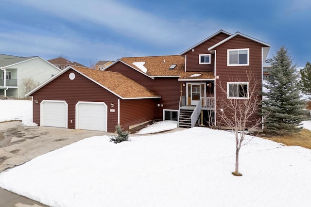 view of front of home with driveway, an attached garage, and roof with shingles