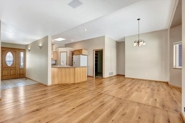 6864 Joy Dr, Missoula, MT 59803 - unfurnished living room featuring light wood-type flooring, a chandelier, and baseboards