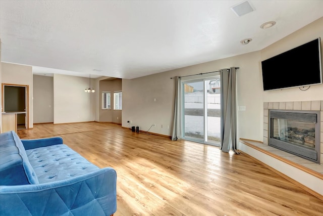 6864 Joy Dr, Missoula, MT 59803 - living room featuring plenty of natural light, a chandelier, light wood-style floors, and a fireplace