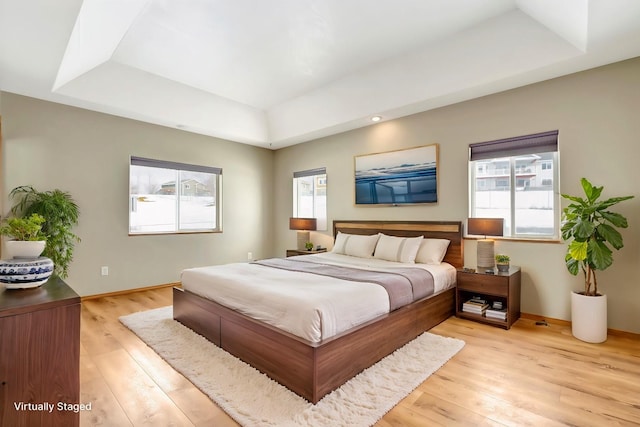 6864 Joy Dr, Missoula, MT 59803 - bedroom with a raised ceiling, light wood-type flooring, multiple windows, and baseboards