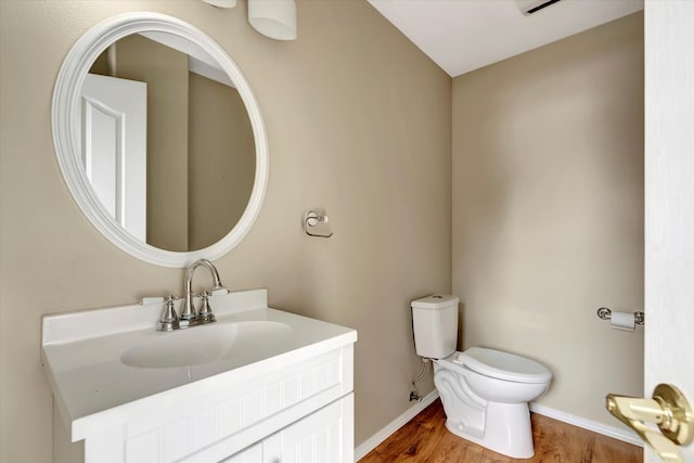 6864 Joy Dr, Missoula, MT 59803 - half bathroom featuring wood finished floors, toilet, vanity, and baseboards
