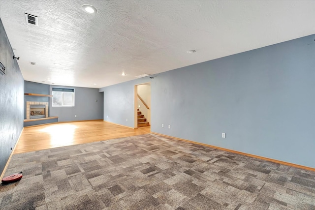 6864 Joy Dr, Missoula, MT 59803 - unfurnished living room with carpet floors, stairway, baseboards, a textured ceiling, and wood finished floors