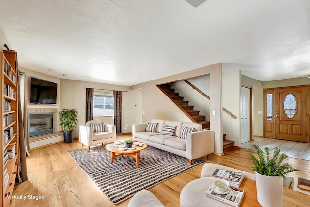 6864 Joy Dr, Missoula, MT 59803 - living area with stairway, a glass covered fireplace, and light wood-style flooring