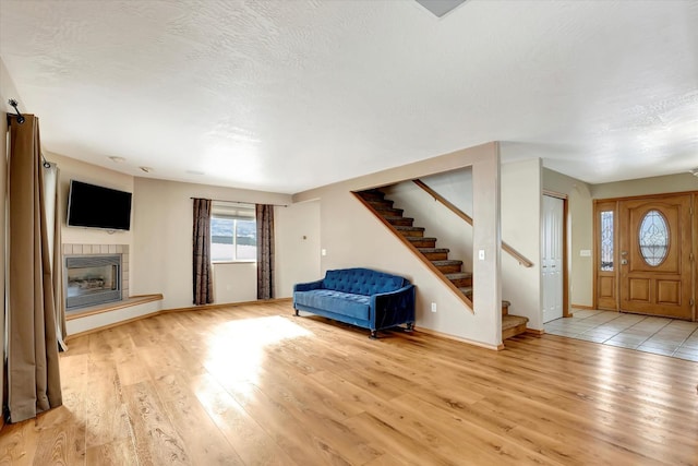 6864 Joy Dr, Missoula, MT 59803 - entrance foyer featuring stairway, light wood-style floors, a fireplace, and baseboards