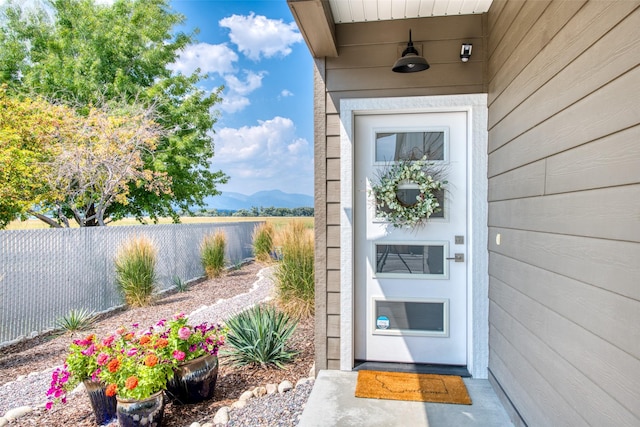 doorway to property featuring fence and a mountain view