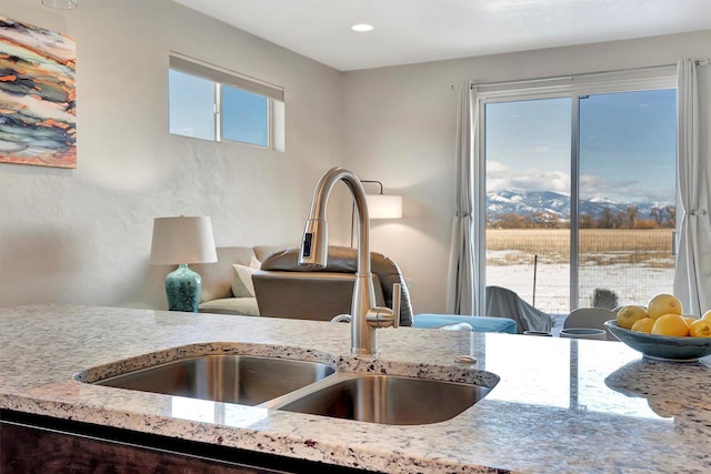 interior details with recessed lighting, a sink, and light stone countertops