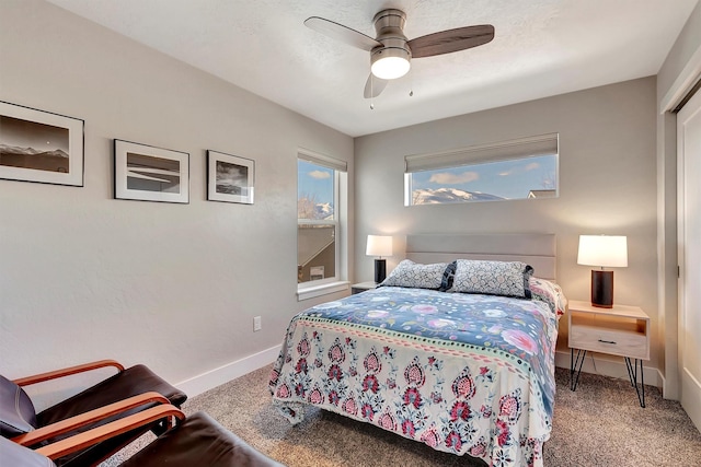 carpeted bedroom featuring a textured ceiling, baseboards, and a ceiling fan