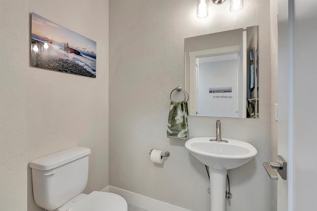 bathroom with a textured wall and toilet