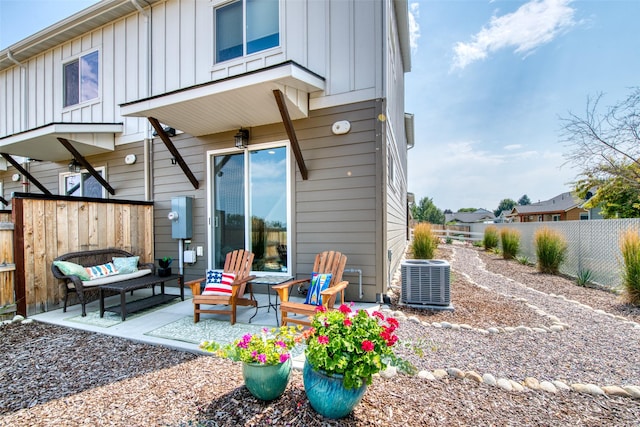 back of house featuring a patio, central air condition unit, fence, an outdoor living space, and board and batten siding