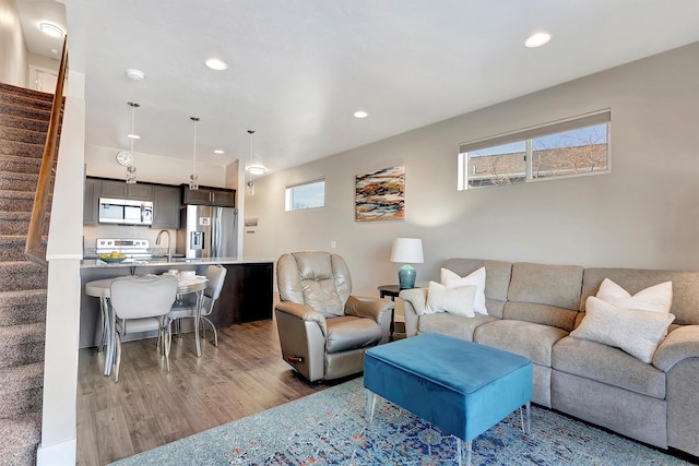 living area with stairway, wood finished floors, and recessed lighting