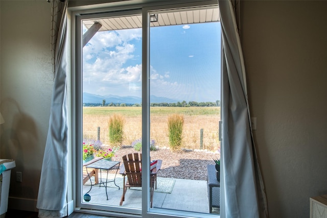 doorway to outside with a rural view and a mountain view