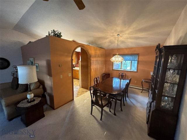 dining space featuring carpet, arched walkways, baseboard heating, and ceiling fan with notable chandelier