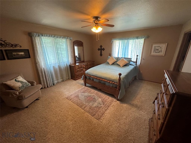 bedroom featuring a textured ceiling, a ceiling fan, and light colored carpet