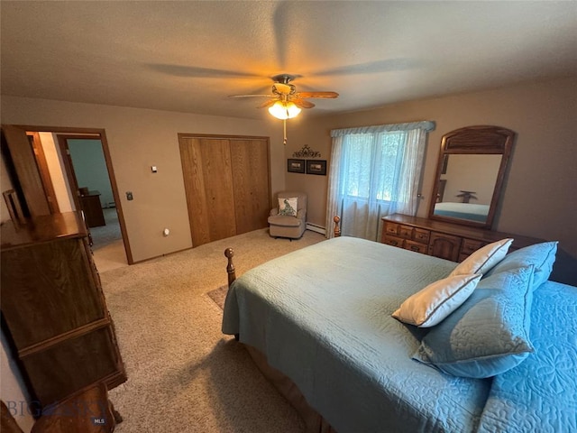 bedroom with a ceiling fan, a closet, and light carpet