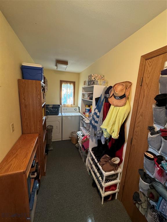 interior space featuring washing machine and dryer and dark colored carpet