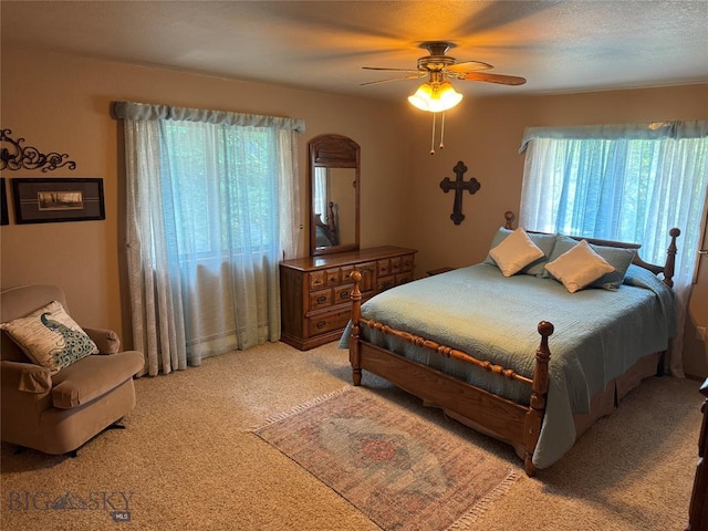 bedroom featuring light carpet, multiple windows, and a ceiling fan