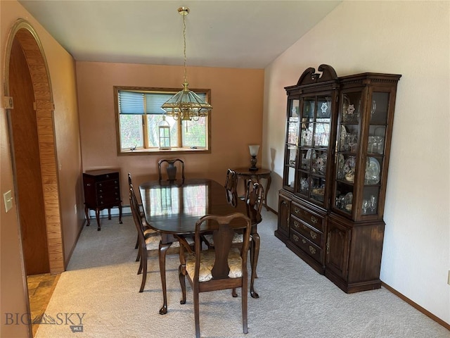 dining area featuring baseboards, a baseboard heating unit, an inviting chandelier, and light colored carpet