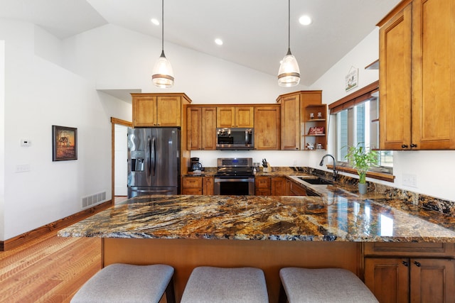 4416 Gem Ranch Rd, Stevensville, MT 59870 - kitchen featuring stainless steel appliances, brown cabinets, open shelves, a peninsula, and dark stone counters
