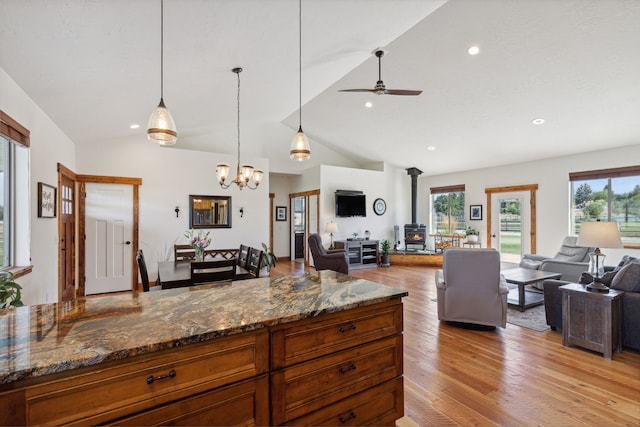 4416 Gem Ranch Rd, Stevensville, MT 59870 - kitchen featuring open floor plan, a wood stove, a ceiling fan, light wood-style floors, and vaulted ceiling