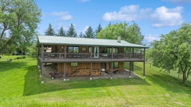 65637 Mt Highway 37, Eureka, MT 59917 - back of property featuring a wooden deck, a lawn, and a chimney