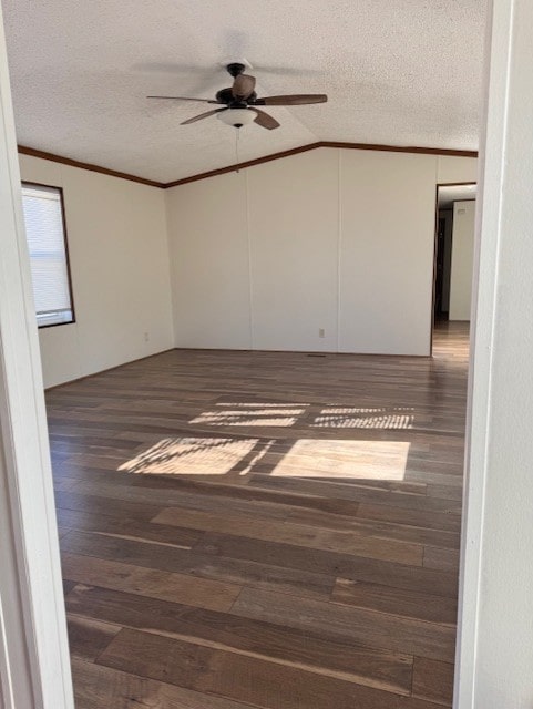 unfurnished room with a textured ceiling, lofted ceiling, wood finished floors, a ceiling fan, and ornamental molding