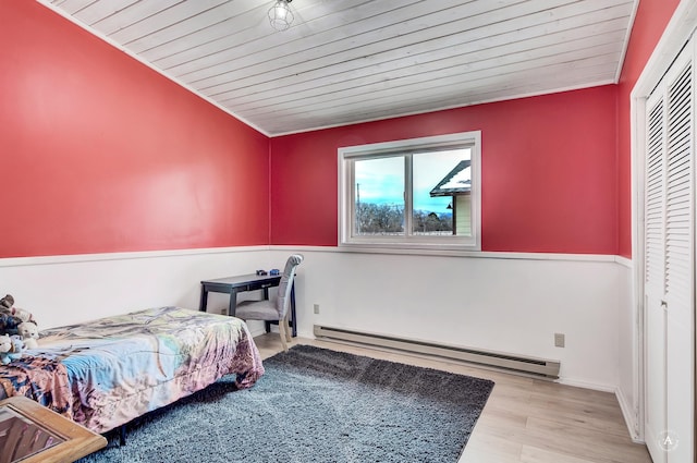 bedroom with a baseboard radiator, wood ceiling, and wood finished floors