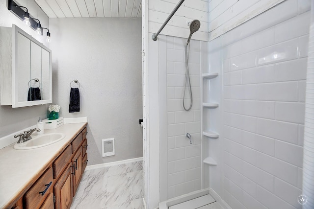 bathroom with vanity, visible vents, baseboards, marble finish floor, and tiled shower