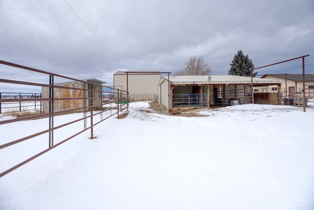 yard layered in snow featuring an outbuilding and an exterior structure