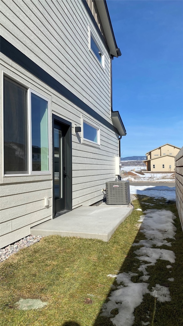 view of side of home featuring a patio area and central AC