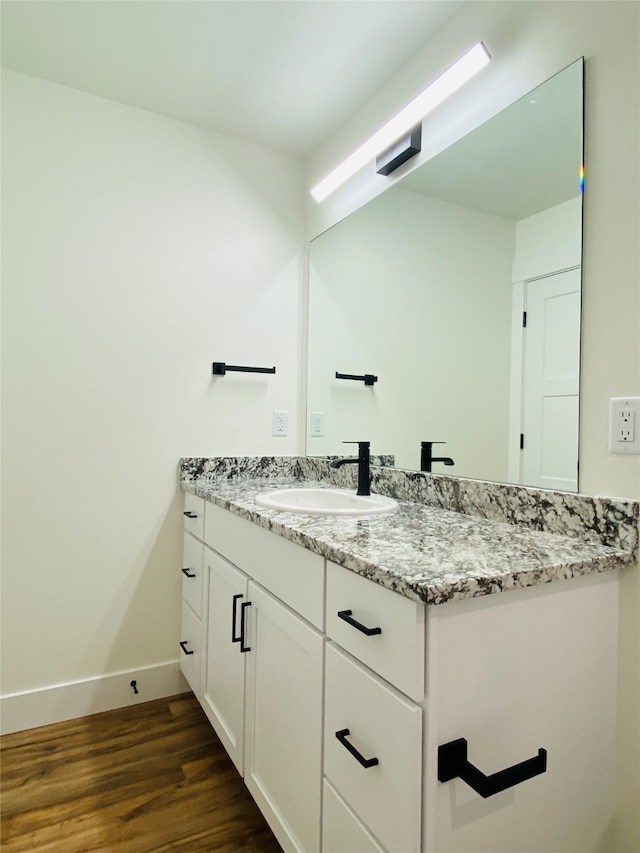 bathroom featuring wood finished floors, baseboards, and vanity
