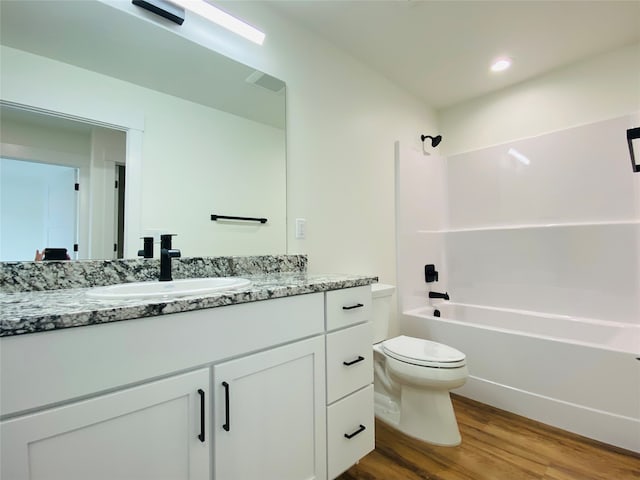 bathroom with recessed lighting, toilet, washtub / shower combination, vanity, and wood finished floors