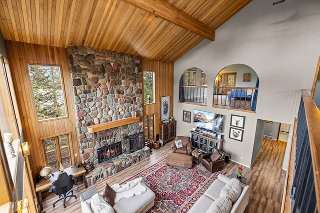 living area with high vaulted ceiling, a fireplace, wood finished floors, and wood ceiling