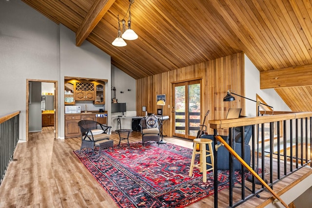 sitting room featuring high vaulted ceiling, wooden ceiling, an upstairs landing, light wood-style floors, and beam ceiling