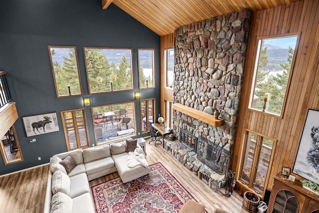 living area with wood ceiling, a fireplace, high vaulted ceiling, and wood finished floors