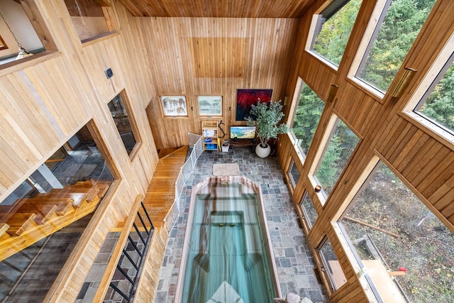 living area with wooden walls and a high ceiling