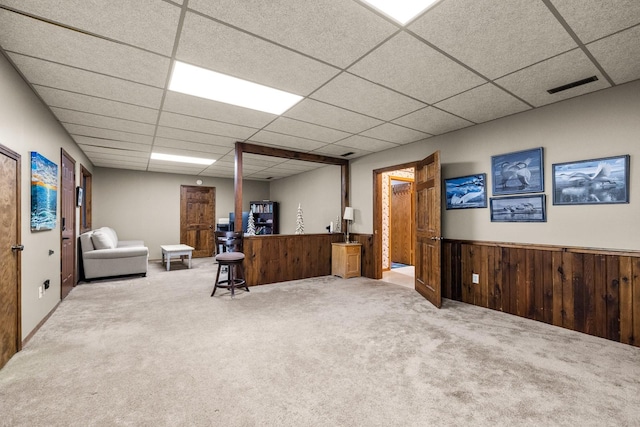 home office featuring a drop ceiling, wood walls, carpet flooring, visible vents, and wainscoting