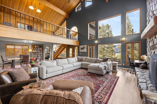 living room featuring high vaulted ceiling, wood finished floors, wood ceiling, stairway, and beam ceiling