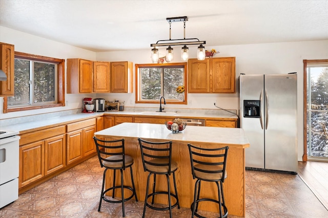 kitchen featuring light floors, light countertops, a sink, and stainless steel fridge with ice dispenser