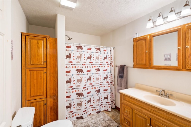 full bathroom with a textured ceiling, curtained shower, toilet, and vanity