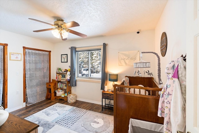 bedroom featuring a ceiling fan, a textured ceiling, baseboards, and wood finished floors