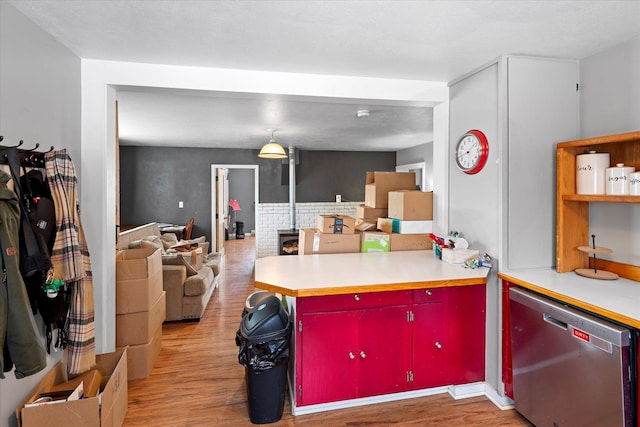 kitchen with light wood-style floors, red cabinetry, open floor plan, dishwasher, and a peninsula