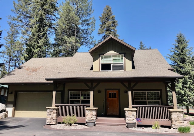 935 Pack Rat Ln, Whitefish, MT 59937 - view of front facade with covered porch, a garage, asphalt driveway, and roof with shingles
