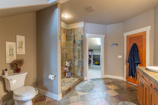 935 Pack Rat Ln, Whitefish, MT 59937 - full bathroom with vanity, a stall shower, toilet, stone tile floors, and baseboards
