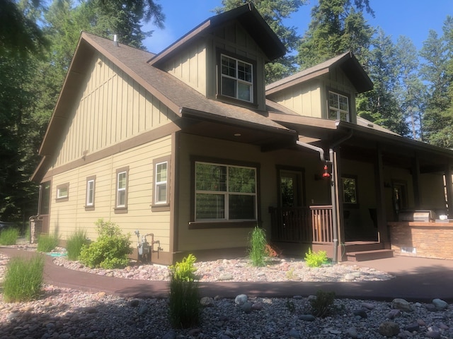 935 Pack Rat Ln, Whitefish, MT 59937 - view of front facade with covered porch, board and batten siding, and roof with shingles